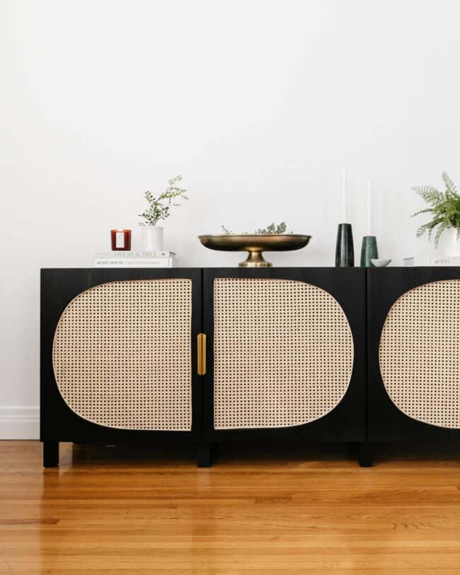 Black cabinet with rattan cane door panels.