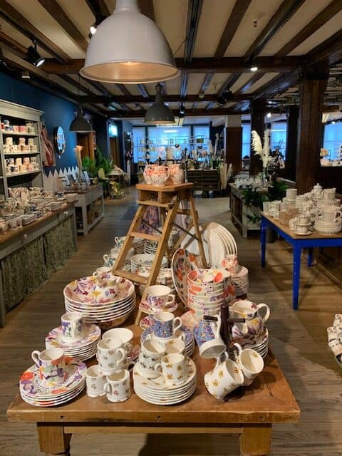 Room in Liberty's London with dressers and tables displaying pretty cups, plates and bowls.