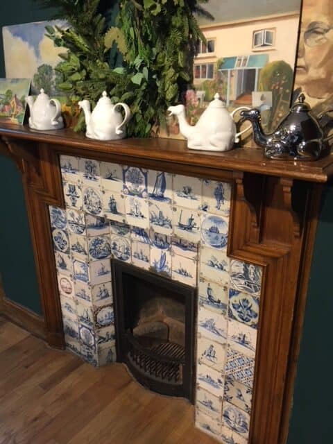 Wooden fireplace with blue and white Delft tiles inside Liberty's of London.