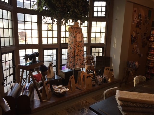 Large bay window featuring windowsill of dressmaking items inside. Liberty's of London.