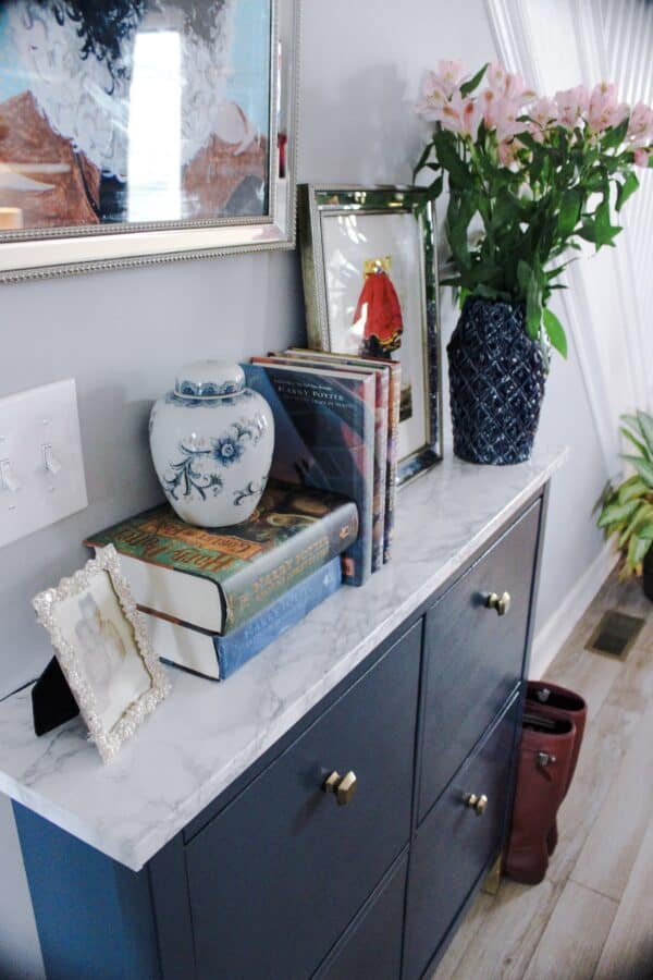 Gray Hemnes shoe storage unit with marble top.