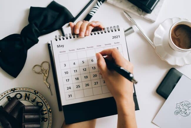 woman's hand writing on calendar.