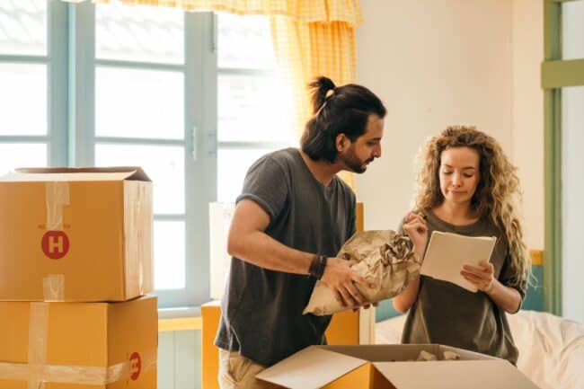 man and woman packing boxes during a home move.