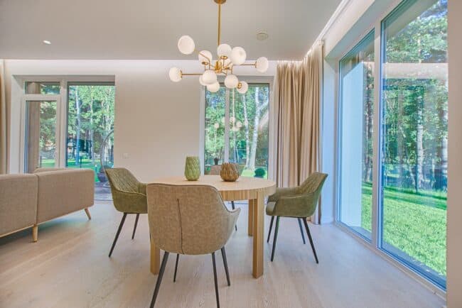 Dining room with dining table and chairs and windows with curtains.